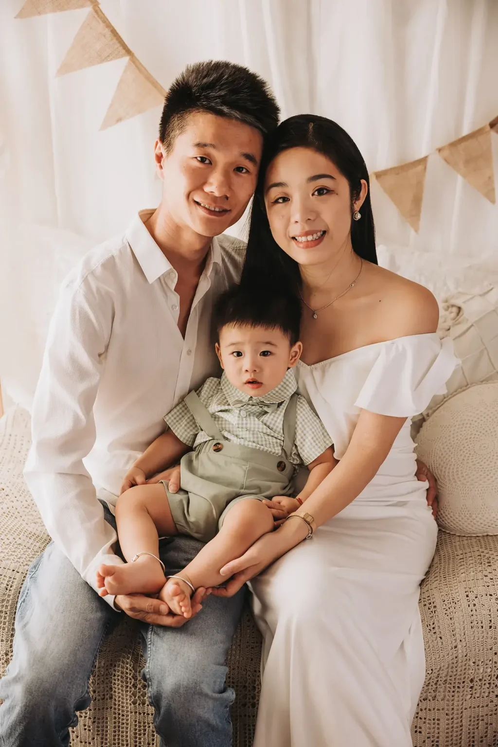 Ritratto di famiglia in studio fotografico a San Severo (Foggia), genitori e bambino seduti in posa naturale, servizio fotografico di famiglia elegante in Puglia