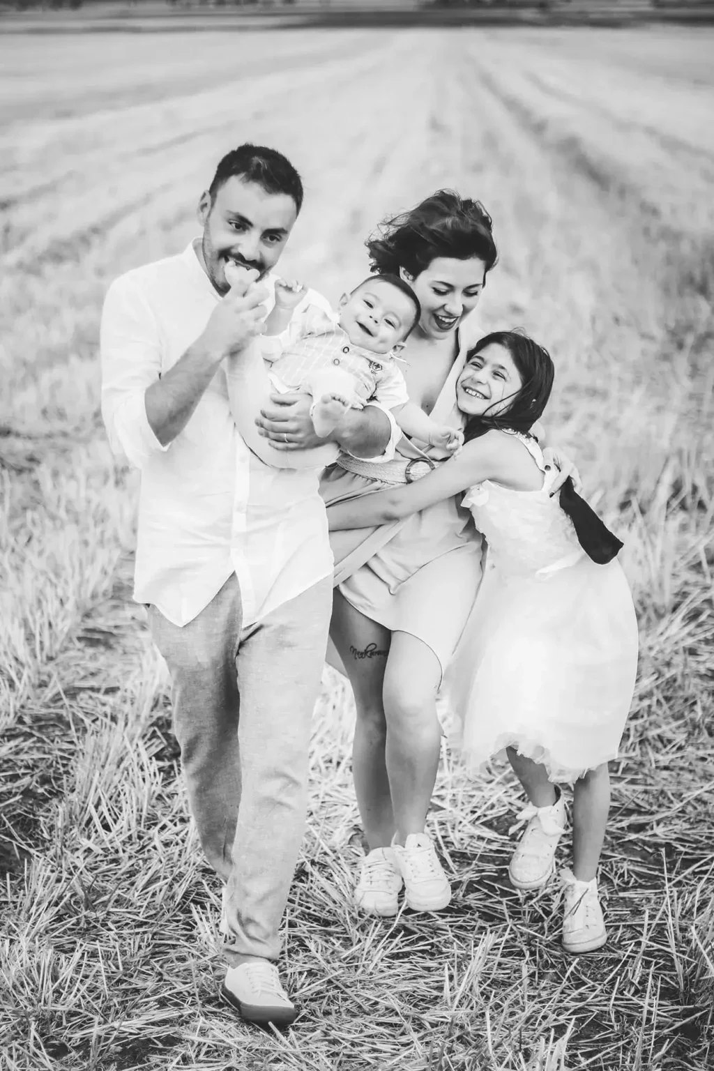 Servizio fotografico di famiglia all’aperto a San Severo (Foggia), ritratto di genitori e bambini in campagna in bianco e nero, fotografia naturale ed emozionale in Puglia