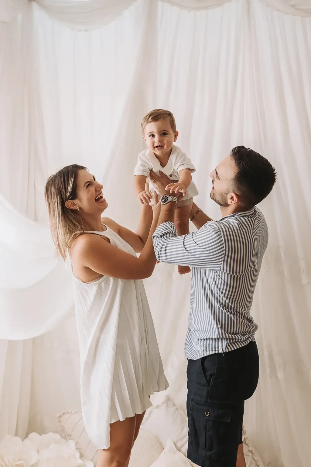 Servizio fotografico di famiglia in studio con genitori e bambino, ritratto naturale e luminoso